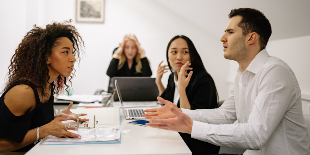 One person calls out another in a serious meeting