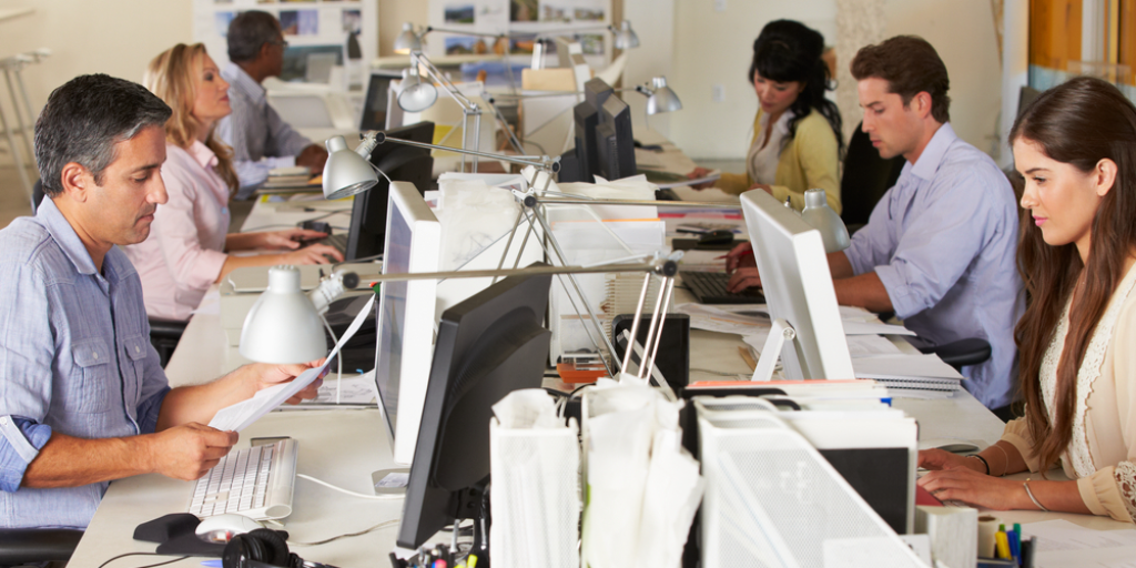 People working at desks in a busy office. This could be you soon.