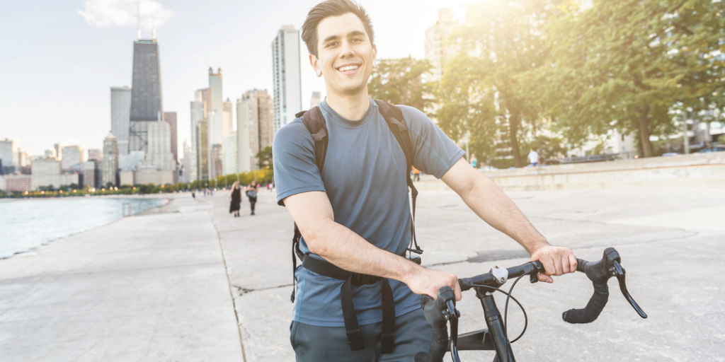 A man with a bicycle with the Chicago skyline in the background