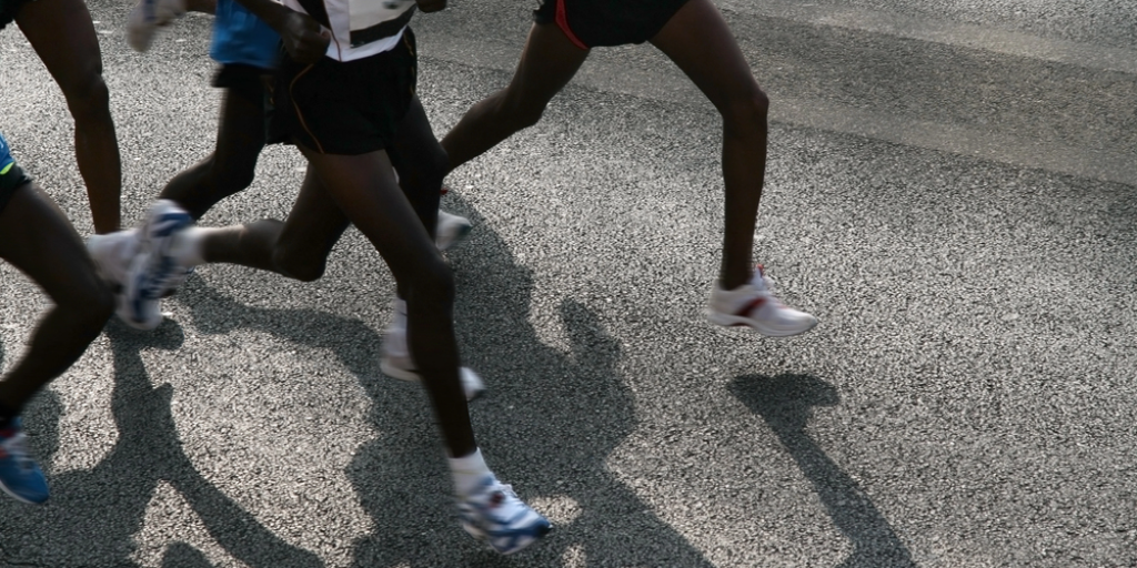 Motion blur photo of men running on a track
