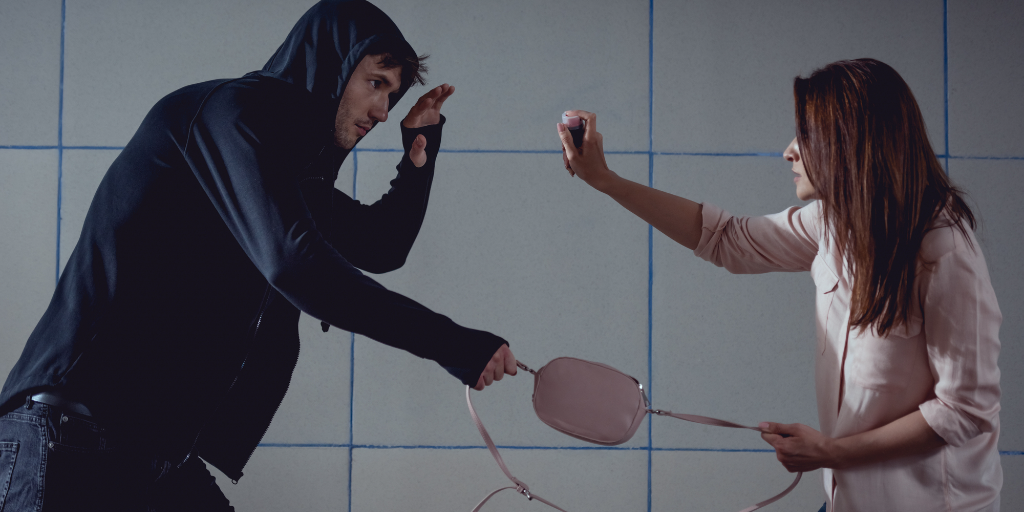 A woman fends off an attack from an assailant.