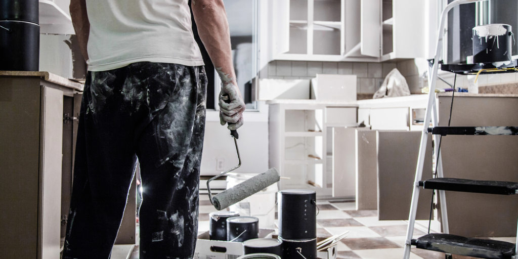 A man looks at a kitchen under renovation