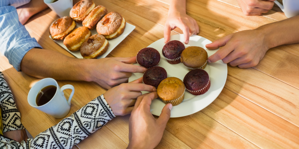 Business people taking cakes on table after lunch in the office
