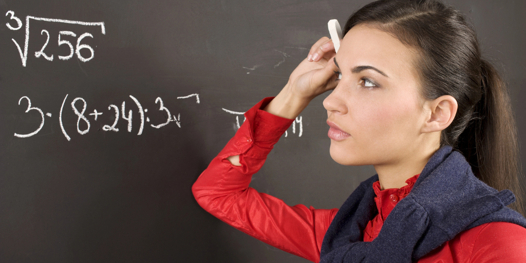 A girl at a blackboard studying a math problem.