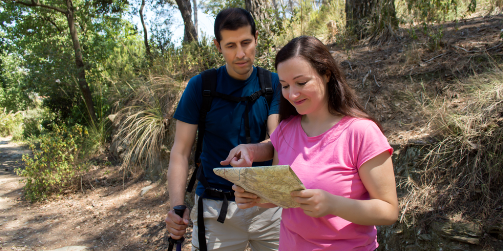A couple is looking at a map to determine if they are heading in the right direction.