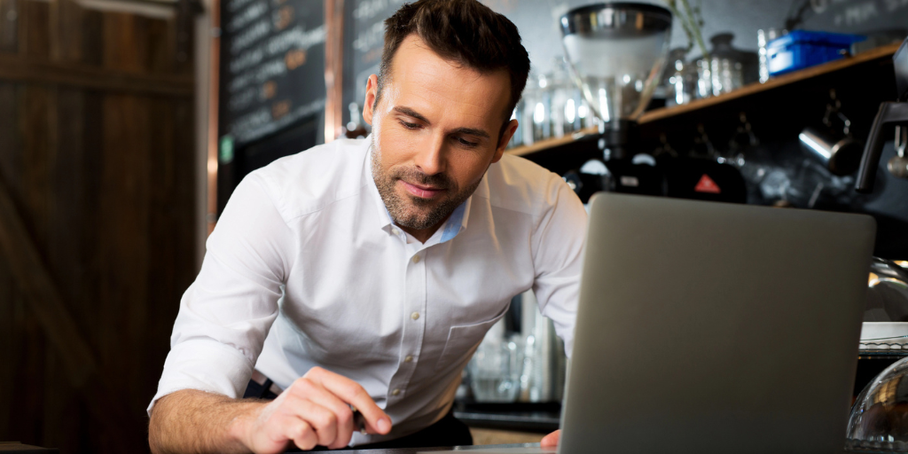 A man at a computer in a café