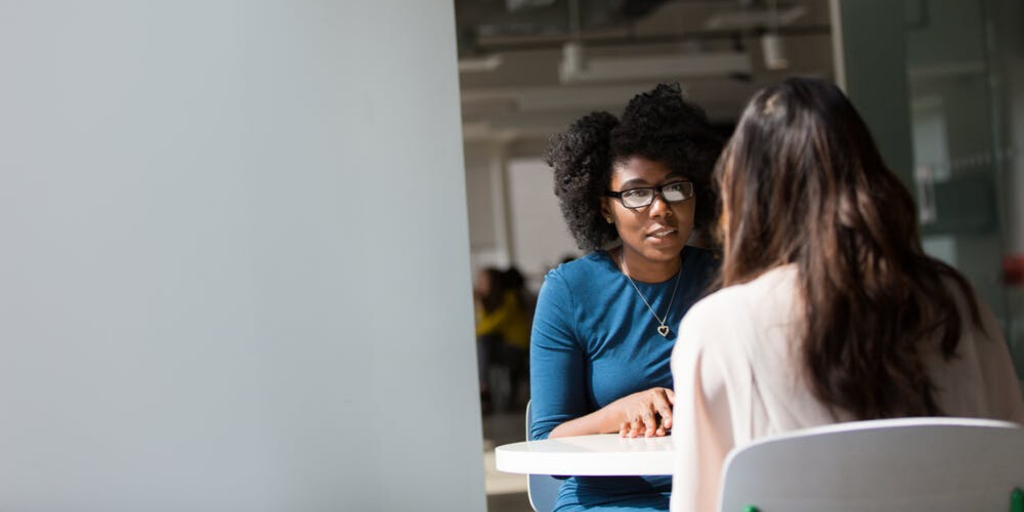 Two women are seated at a café table
