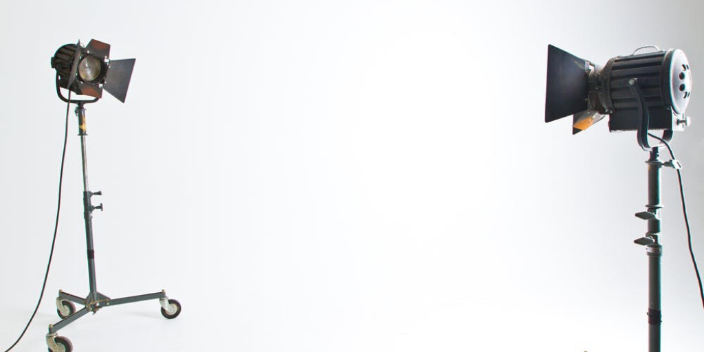 Two lights focus on a single point in a white photography studio